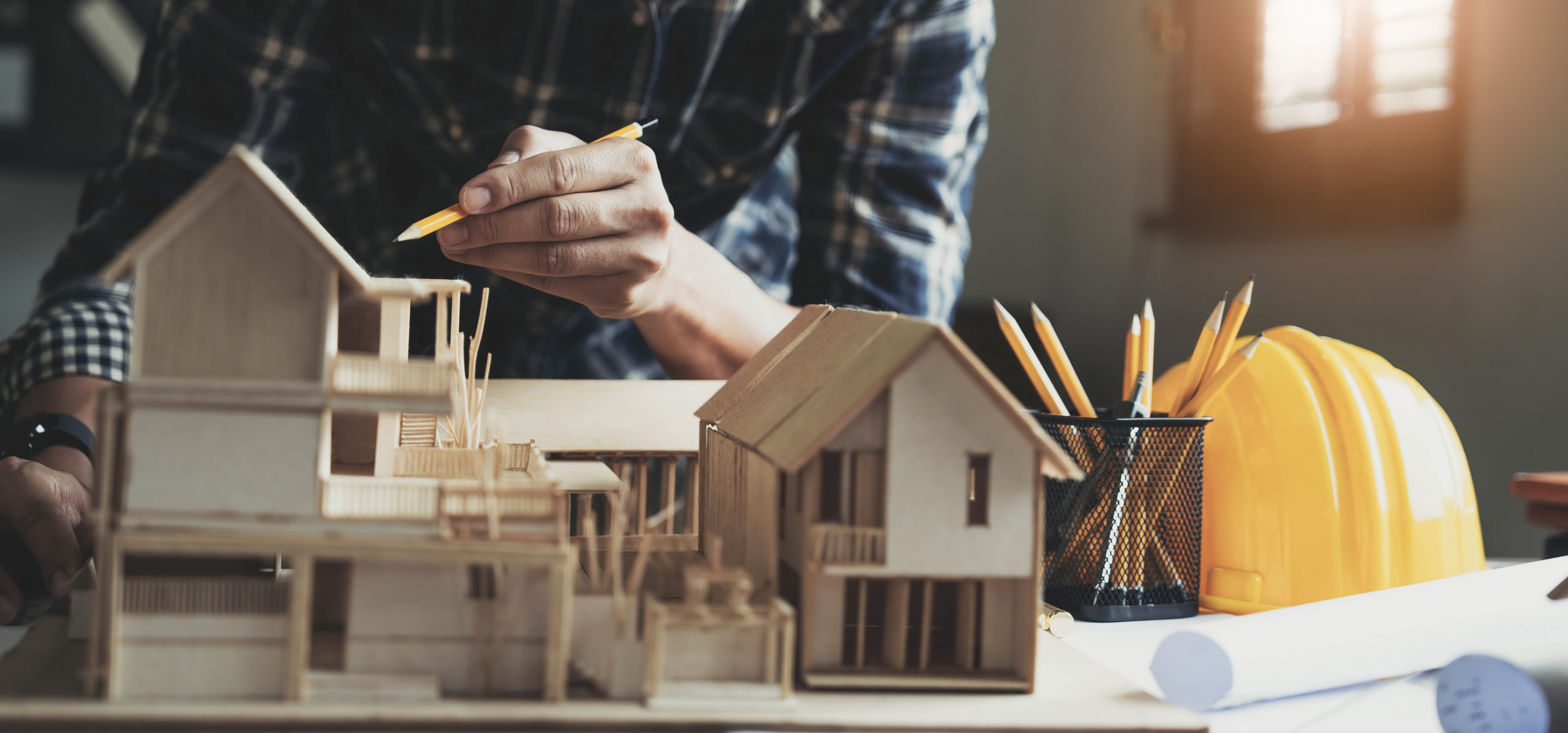 Concept architects, engineer holding pen pointing equipment architects On the desk with a blueprint in the office, Vintage, Sunset light.Selective Focus..